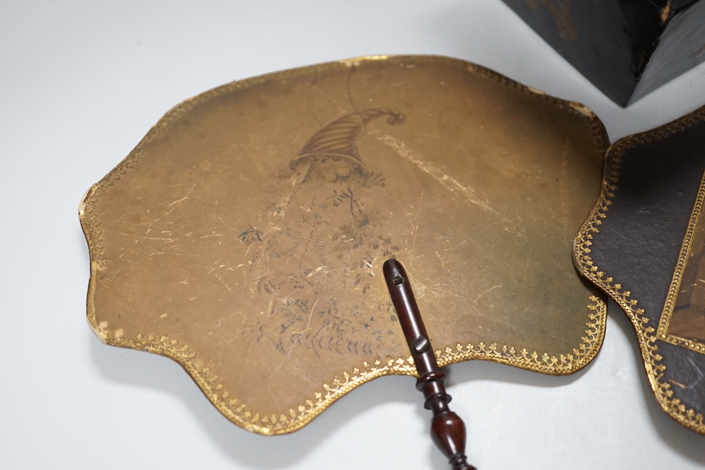 A pair of 19th century face fans, 36cm high, and a black lacquer tea caddy